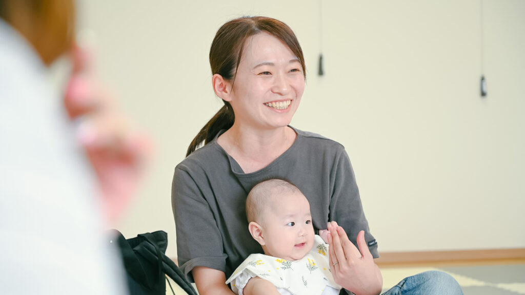 笑顔で赤ちゃんを抱っこするお母さん