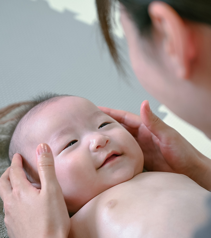 笑顔で顔を見つめる赤ちゃん