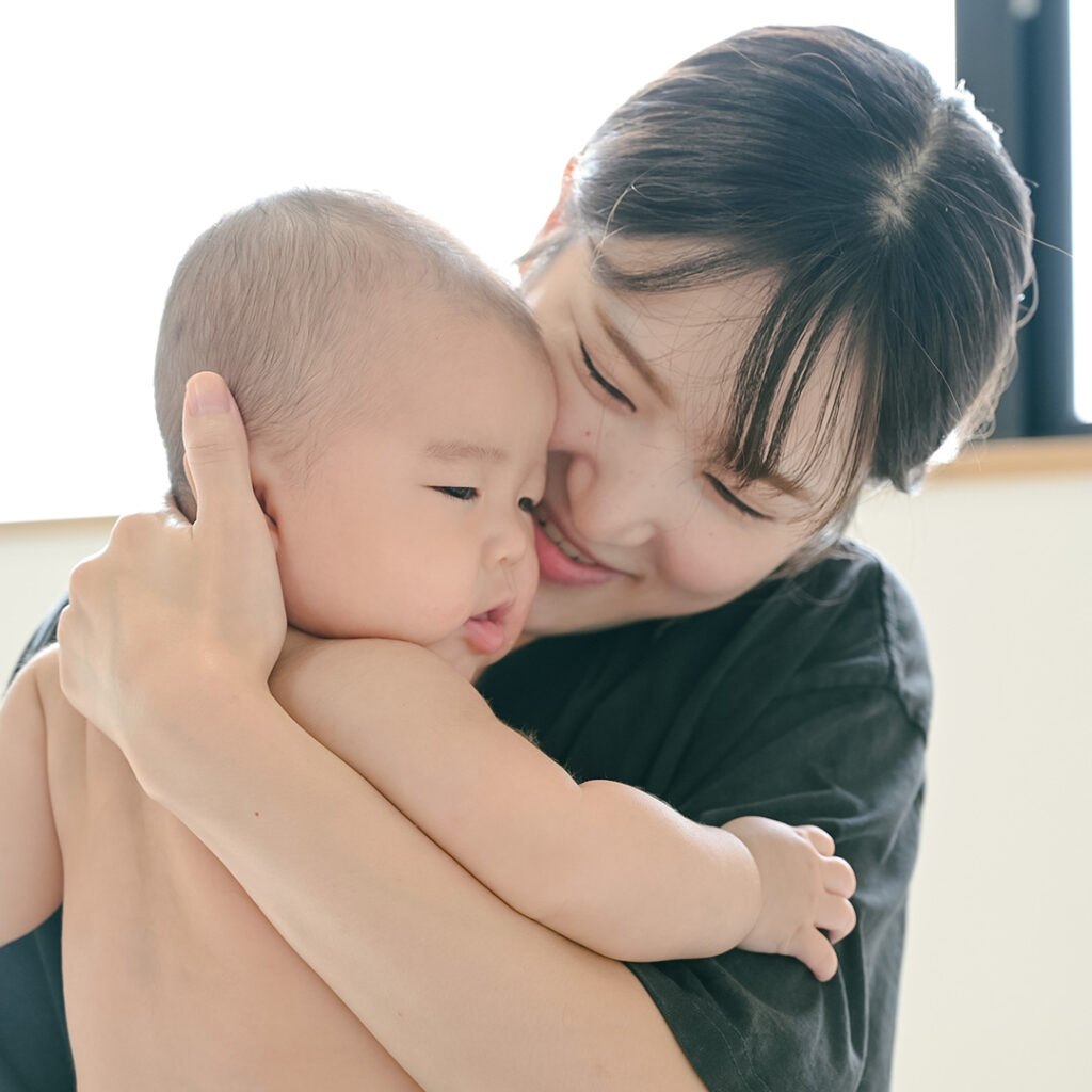 笑顔で抱っこをするお母さん