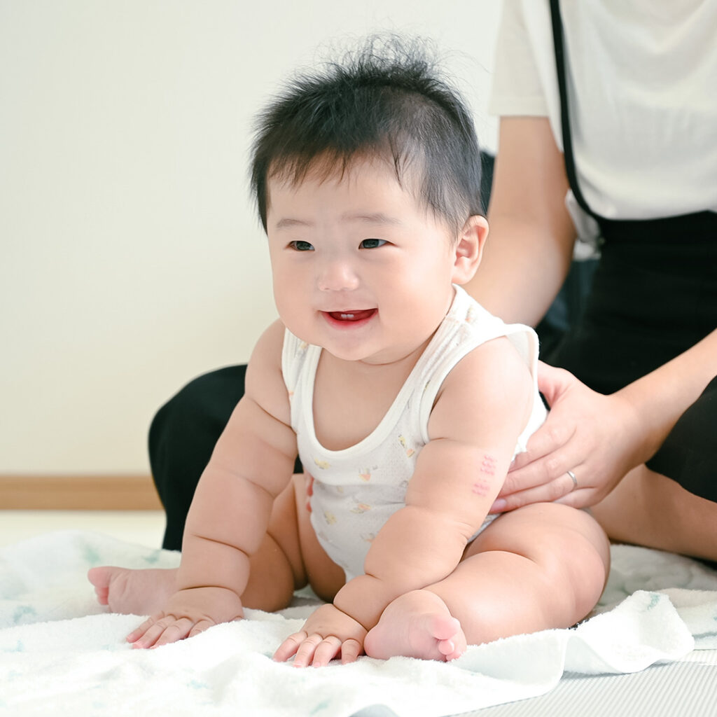 笑顔で座る赤ちゃん